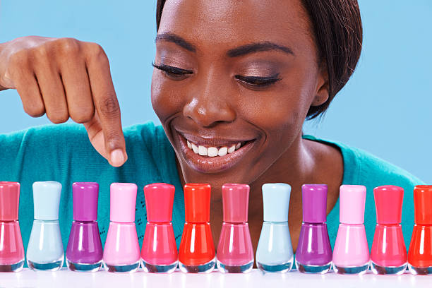 A young african woman looking over a row of colorful nail polish