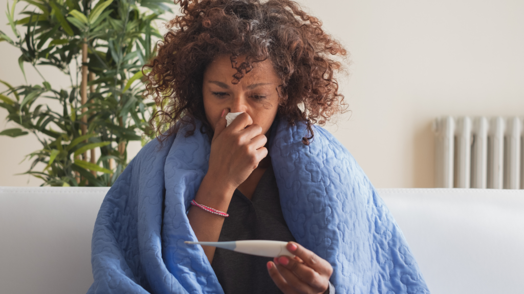 Ill woman with cold or flu checking temperature