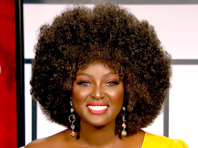 Head shot of Amara La Negra with a yellow shirt off the shoulder