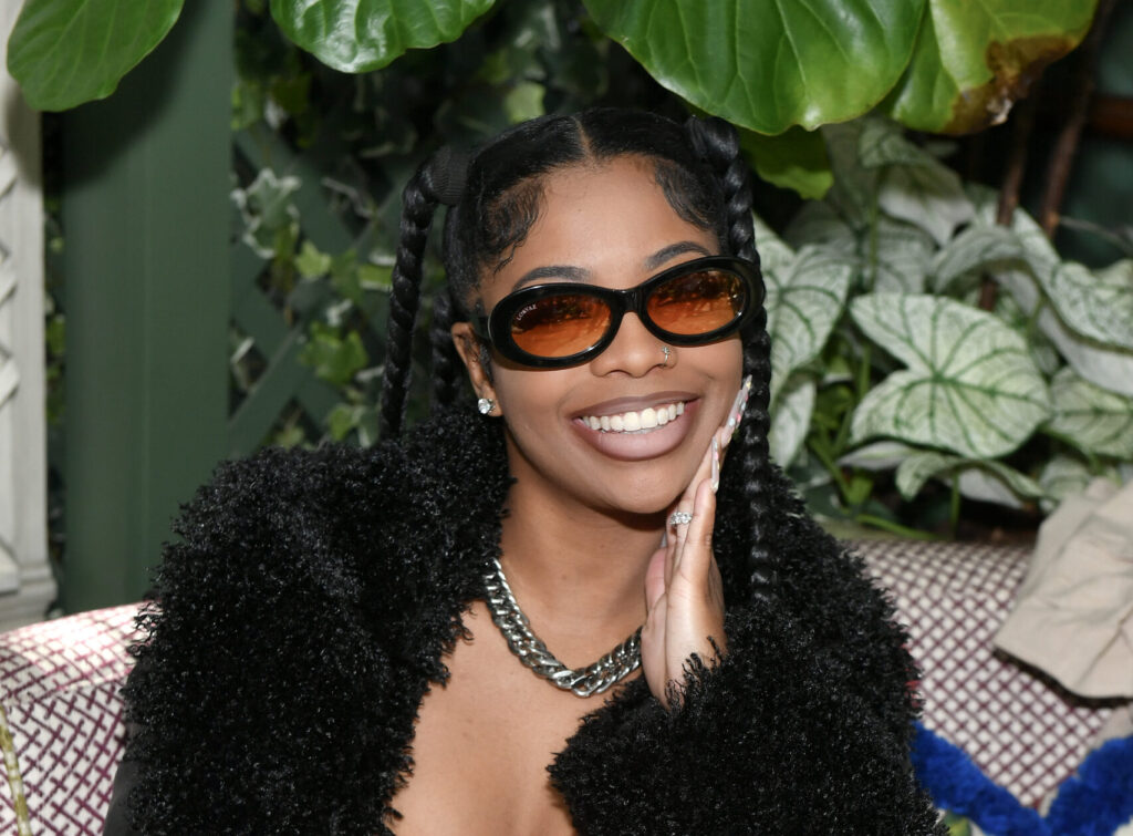 Youtuber De'arra Taylor posing and smiling while sitting down at an event