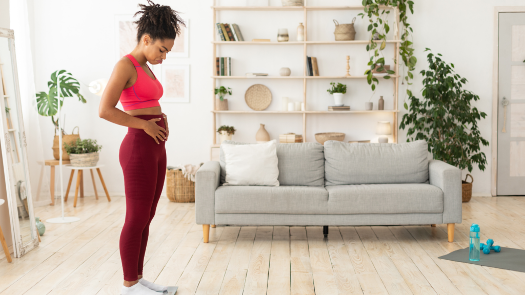 Woman Feeling Unhappy standing on scale holding stomach