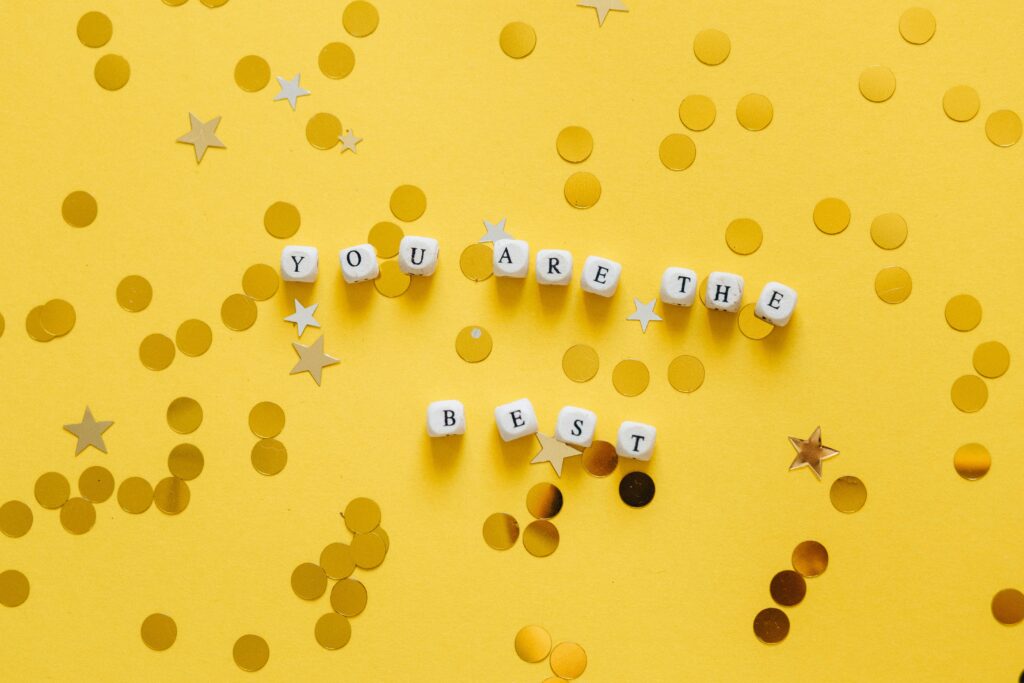 a confetti decorated sign of a compliment: you are the best 