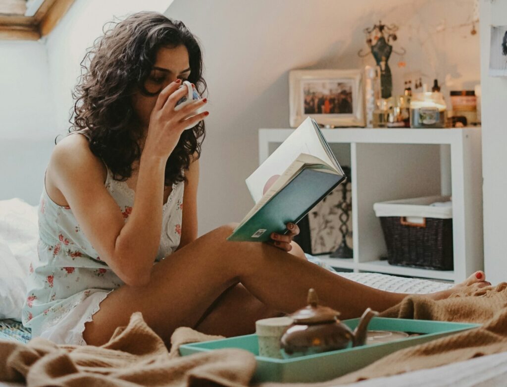 October New Moon 2024 pictured: woman reading and drinking tea