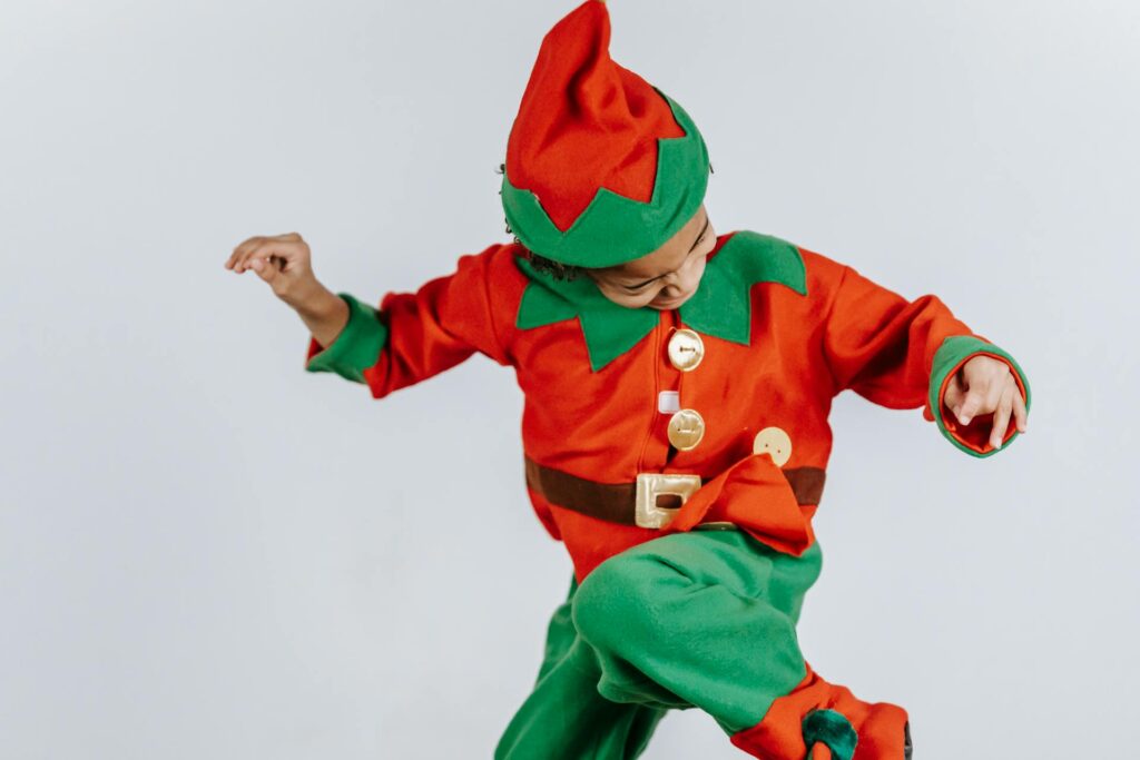 Kid dances in red and green elf costume