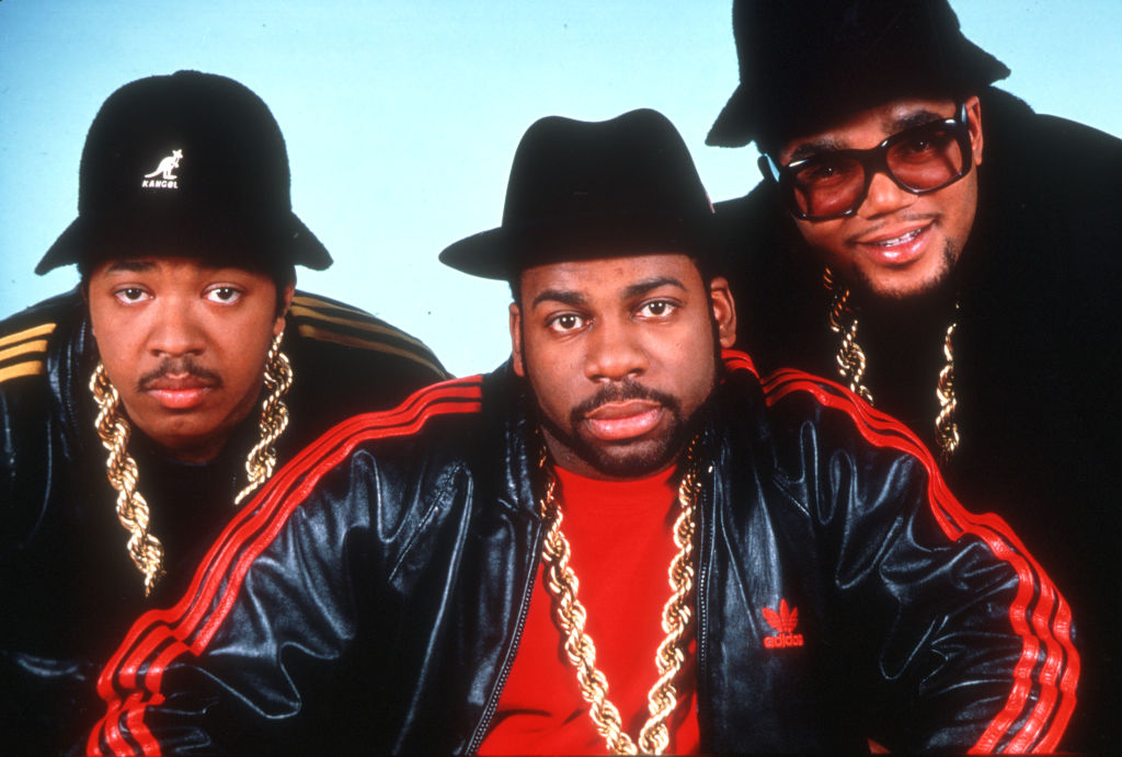 American hip hop band Run-DMC, circa 1985, wearing gold chains, red and black attire and Kangol hats.